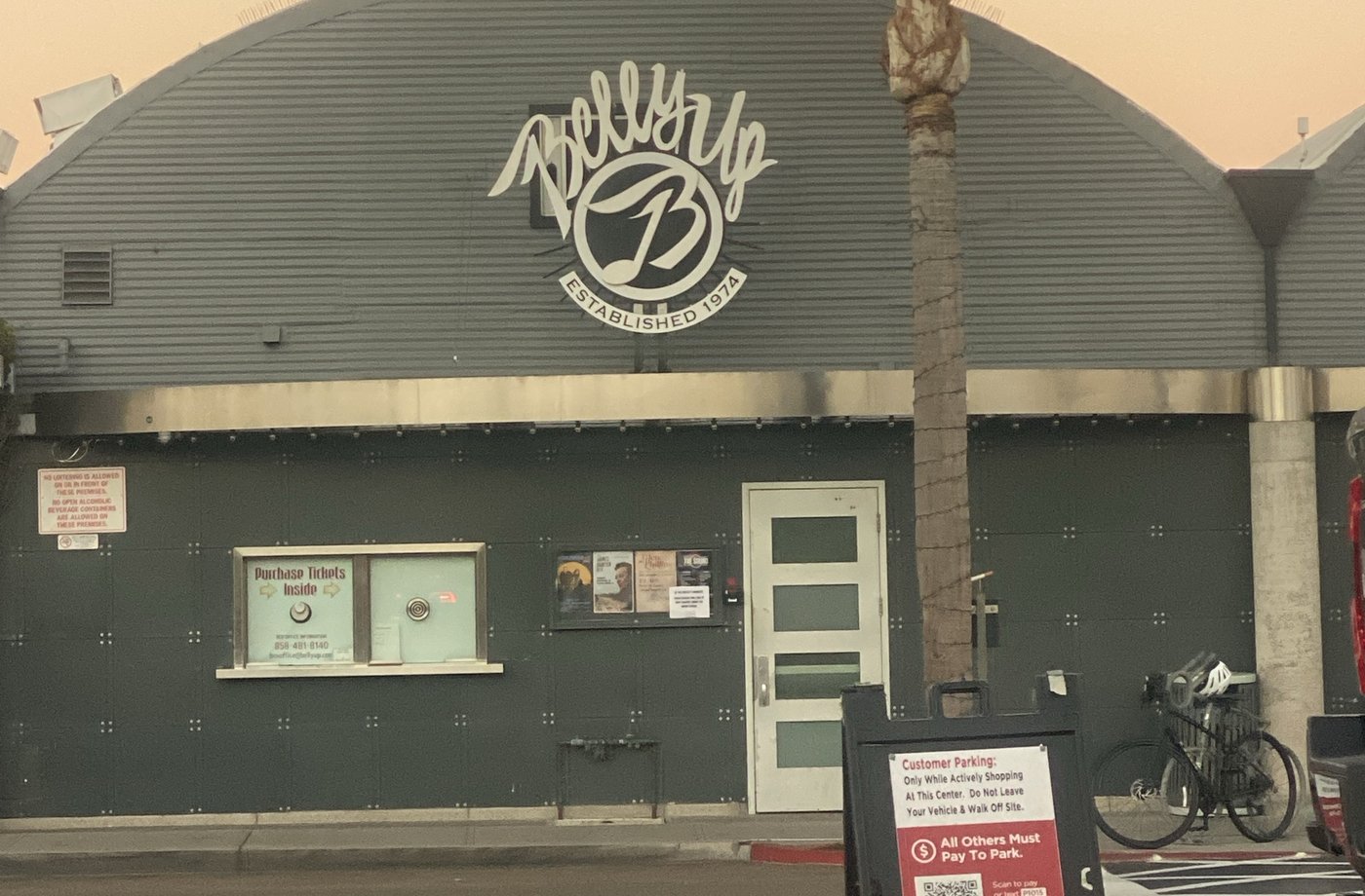 The Belly Up's arched front on Cedros at dawn, with an A-frame parking sign in the lot out front