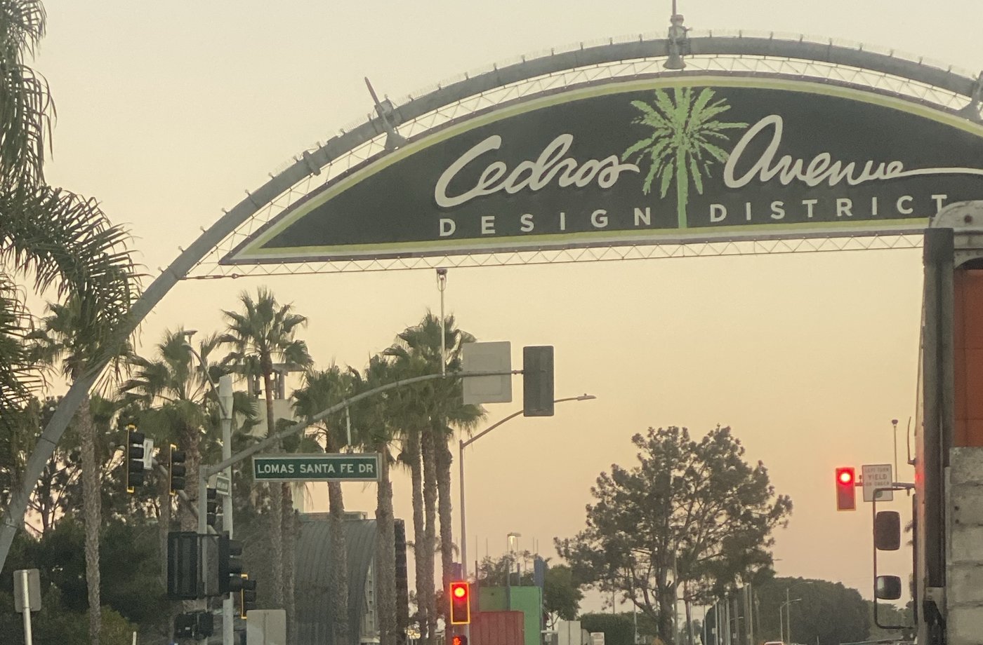 The Cedros Avenue Design District arch over Cedros at Lomas Santa Fe Dr, palms behind it at dawn