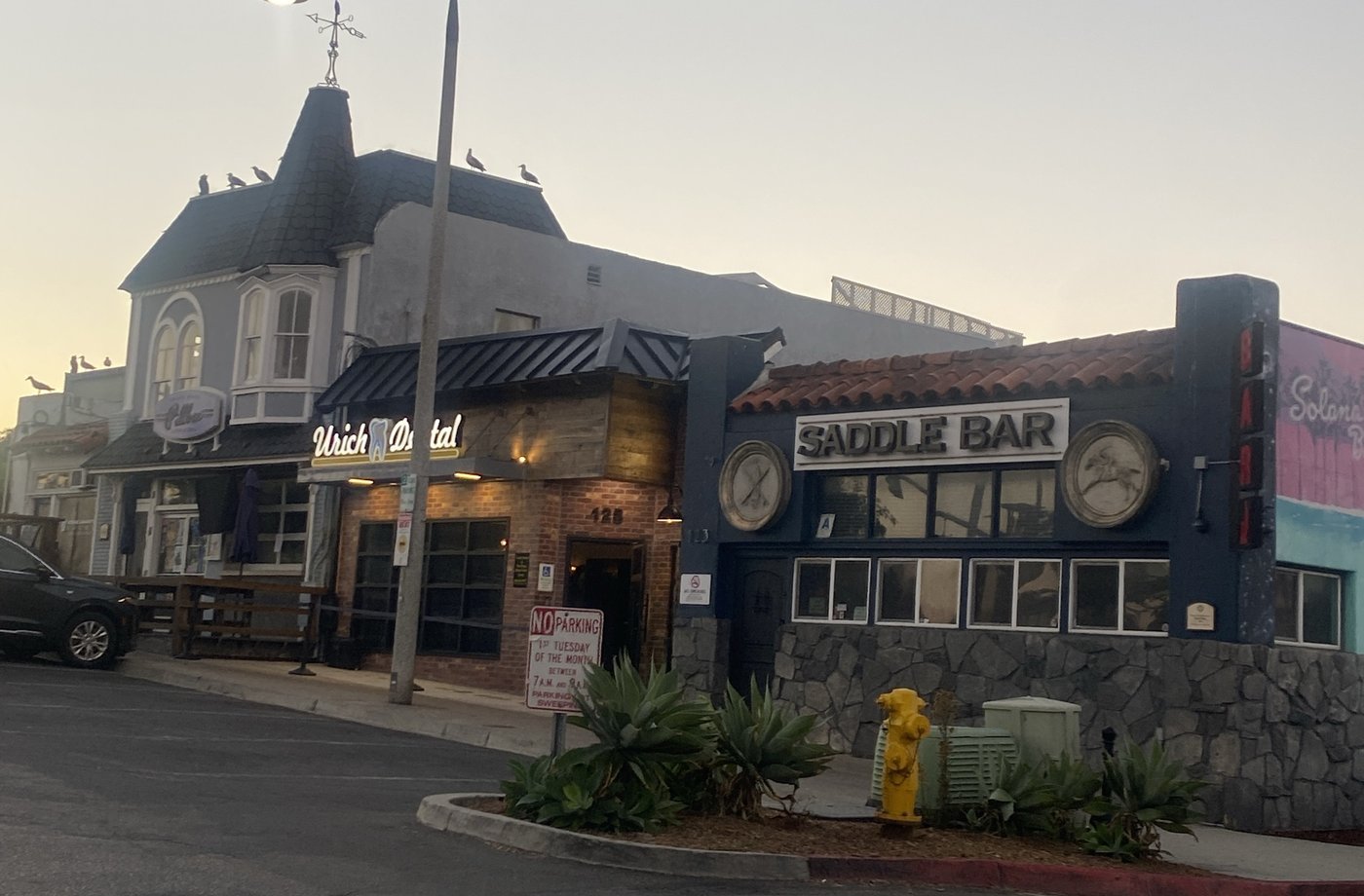 Saddle Bar, Urich Dental and a turreted Victorian-style building with gulls on the roof, at dawn in Solana Beach