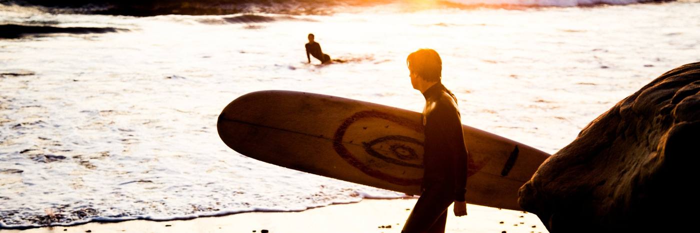 A surfer at golden hour in Carlsbad