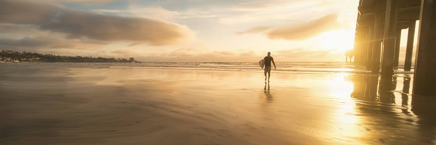 A surfer at sunset in San Diego